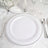 White dinner plate with silver rim on an elegant table setting.