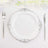 Elegant white plate with silver ornate detailing, styled with cutlery.