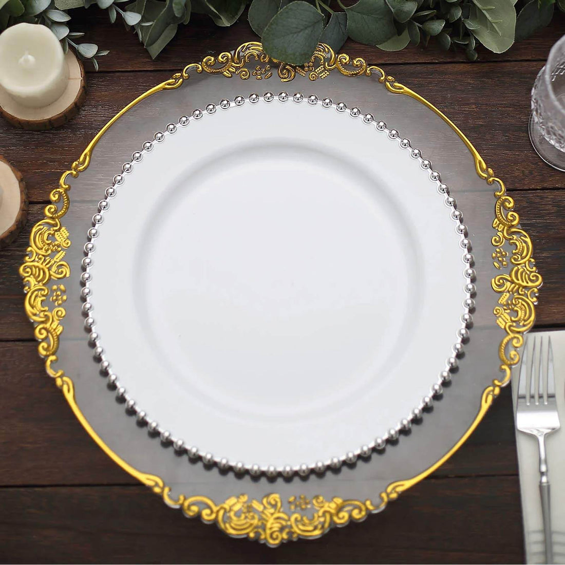 Elegant decorative charger plate with gold and silver accents on a wooden table.