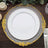 Elegant decorative charger plate with gold and silver accents on a wooden table.