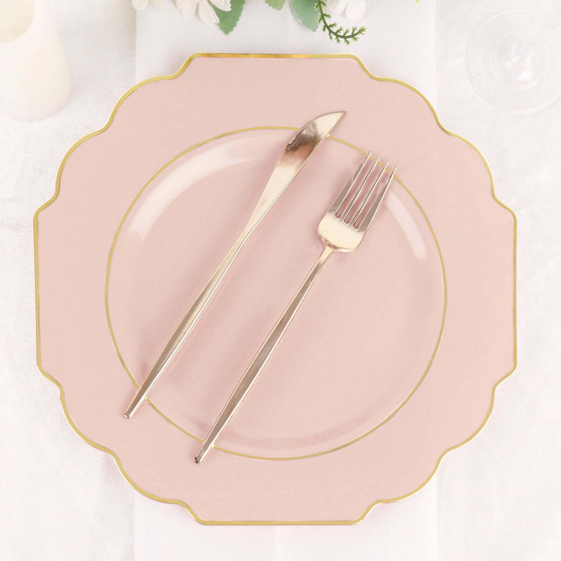 Pink scalloped plate with gold trim and silver knife and fork