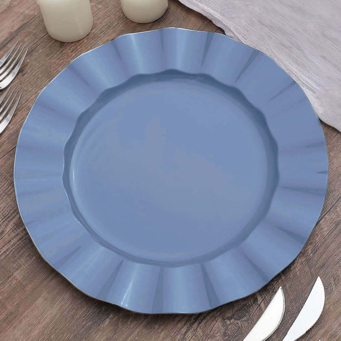 Blue scalloped dinner plate on a wooden table setting.