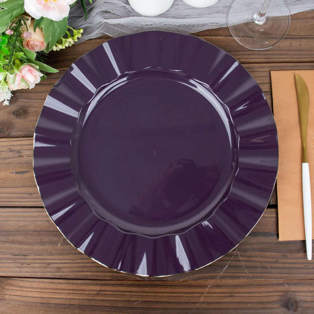 Purple decorative plate on a wooden table with floral accents.