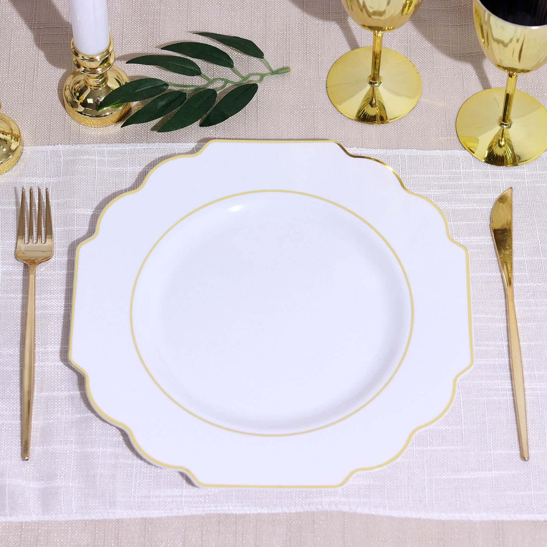 Elegant white scalloped plate with gold trim, styled with golden utensils and decor.