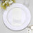 Elegant white dinner plate with a decorative napkin and cutlery set.