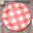 Red and white checkered disposable plate on a wooden table.