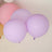 Purple and pink balloons floating together in a bright setting.