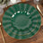 Green decorative plates with gold trim on a wooden table setting.