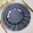 Three elegant gray plates with gold trim arranged on a table setting.
