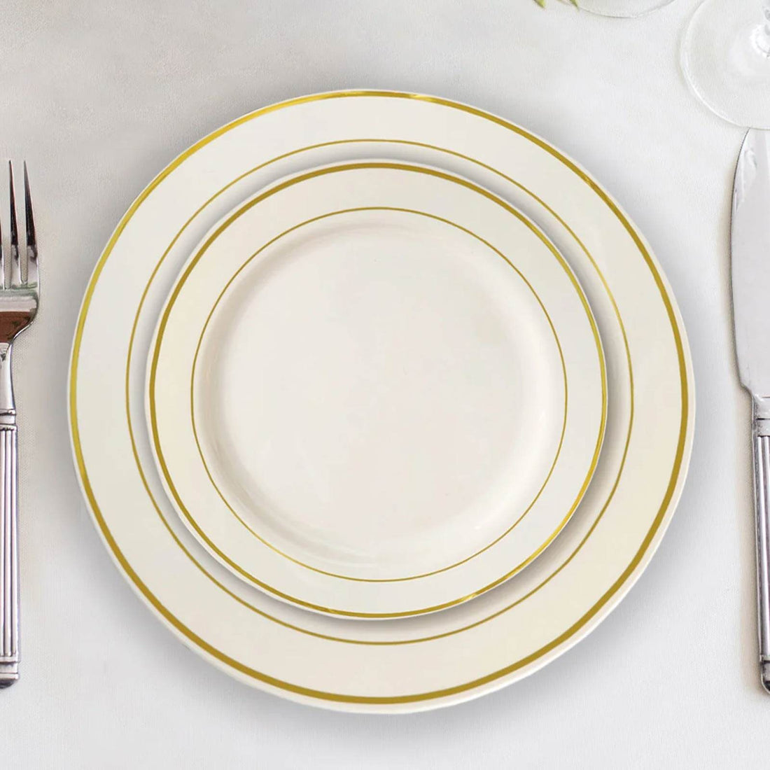 Elegant white dinner plates with gold trim in a stacked arrangement.