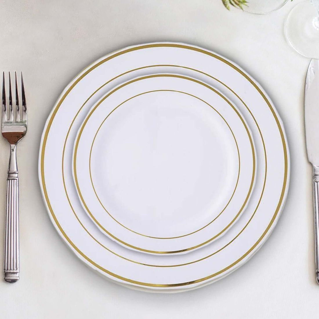 Elegant white dinner plates with gold rims in a stacked arrangement.