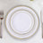 Elegant white dinner plates with gold rims in a stacked arrangement.
