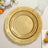 Gold decorative plates stacked on a table with floral accents.