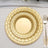 Elegant gold woven plates set on a dining table with silverware.