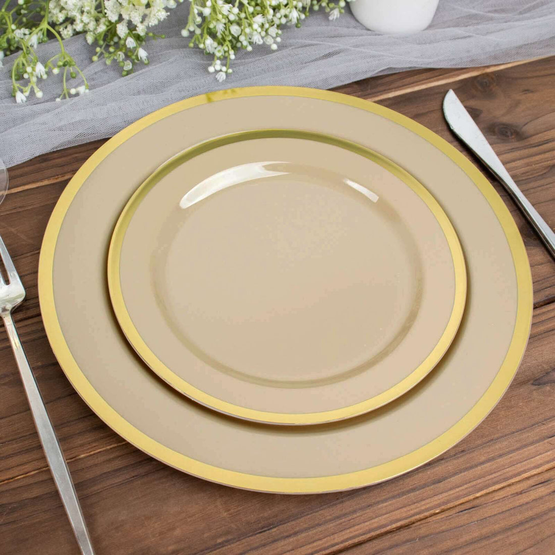 Elegant stacked plates with gold trim on a rustic wooden table.