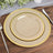 Elegant stacked plates with gold trim on a rustic wooden table.