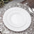 White decorative plates on a silver placemat with cutlery.