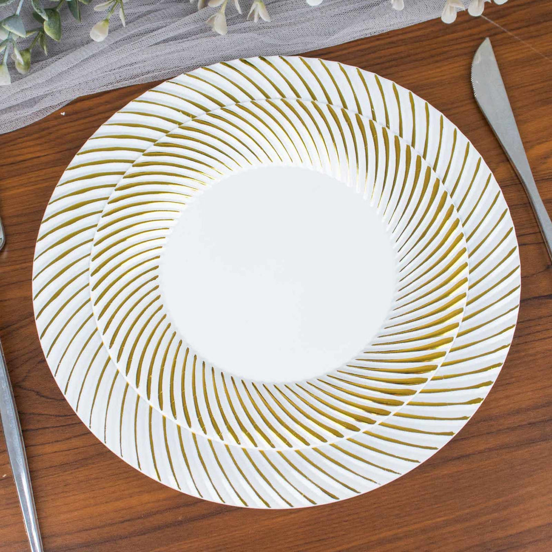 Elegant gold-striped dinner plate on a wooden table setting.