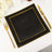 Black dinner plates with gold trim on a white table setting.