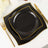 Elegant black plates with gold trim stacked on a white tablecloth.