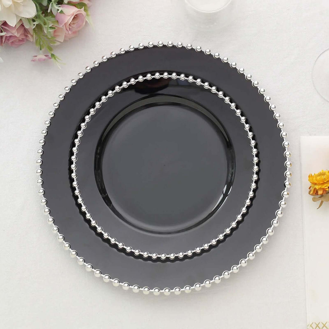 Black dinner plates with silver beaded rims, stacked elegantly.