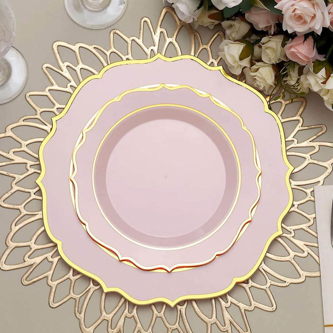 Elegant pink dinner plate with gold trim on decorative lace charger.