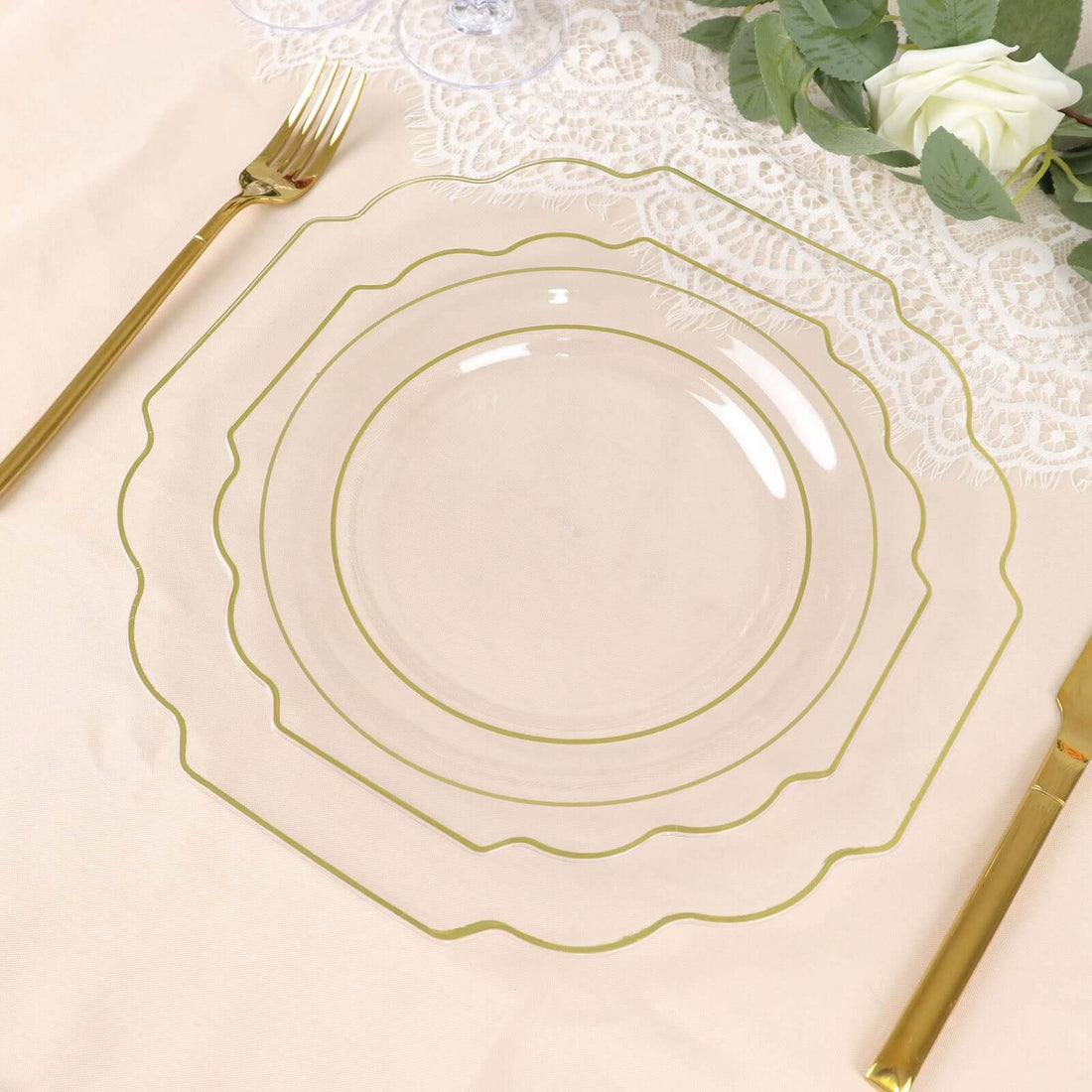 Elegant clear glass plates with gold trim on a soft beige table setting.