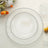 Clear glass plates with beaded edges, arranged in three sizes.