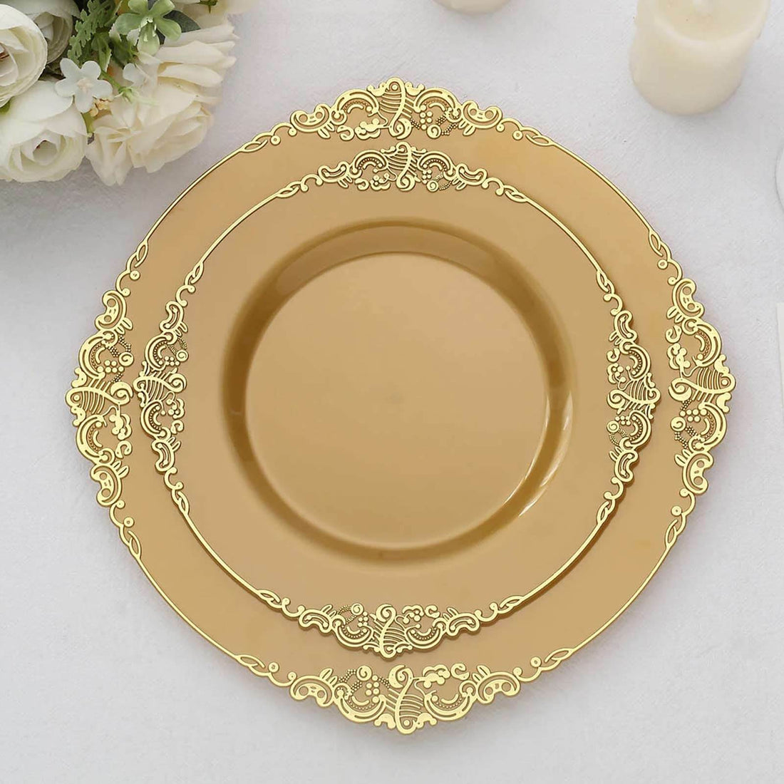 Gold decorative plates stacked elegantly on a white tablecloth.