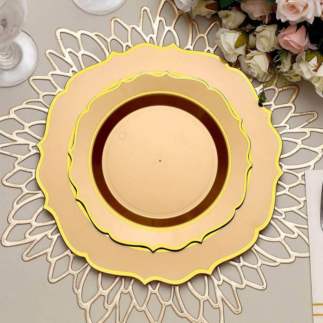 Elegant gold charger plates stacked on a decorative lace placemat.