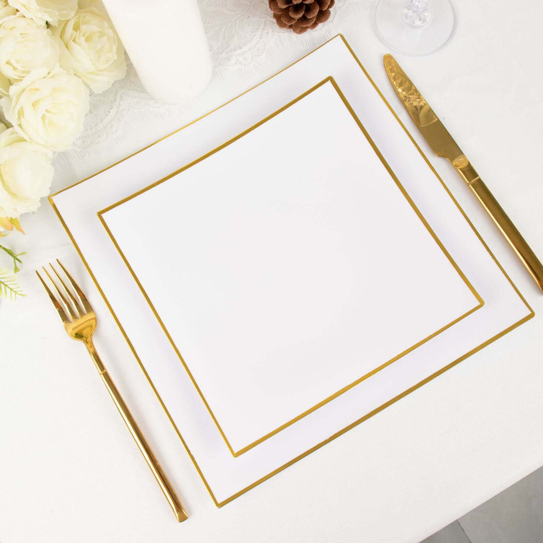 Elegant white plate with gold trim, fork, and knife on a table setting.