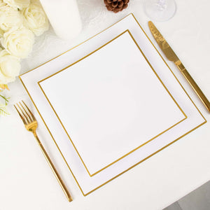 Elegant white plate with gold trim, fork, and knife on a table setting.