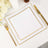 Elegant white plate with gold trim, fork, and knife on a table setting.