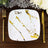 Square white plate with gold marbling design, styled with gold cutlery.