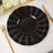 Black decorative plates with gold trim on a dining table setting.