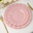 Pink scalloped plates with gold trim on a table setting.