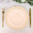 Elegant peach dinner plate with gold cutlery on a lace table setting.