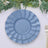 Blue decorative plates layered on a table with greenery and cutlery.