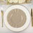 Elegant beige dinner plate on decorative charger with gold utensils.