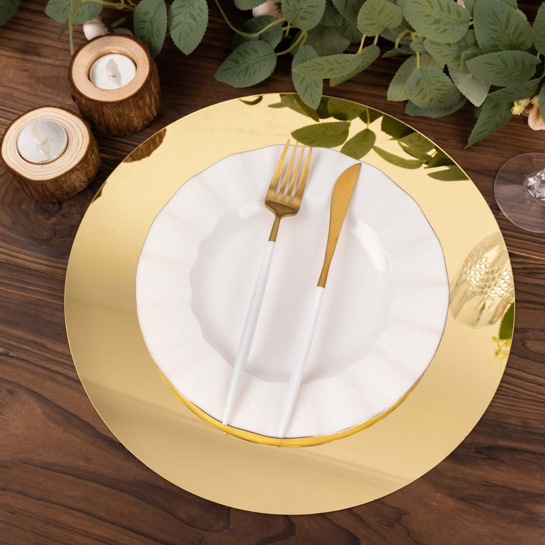 Elegant gold charger plate with white ruffled plate and gold utensils on a wooden table.