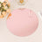 Round rose gold mirror charger plate on a table with flowers and decor.