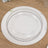 Clear decorative plate with beaded rim on wooden table.