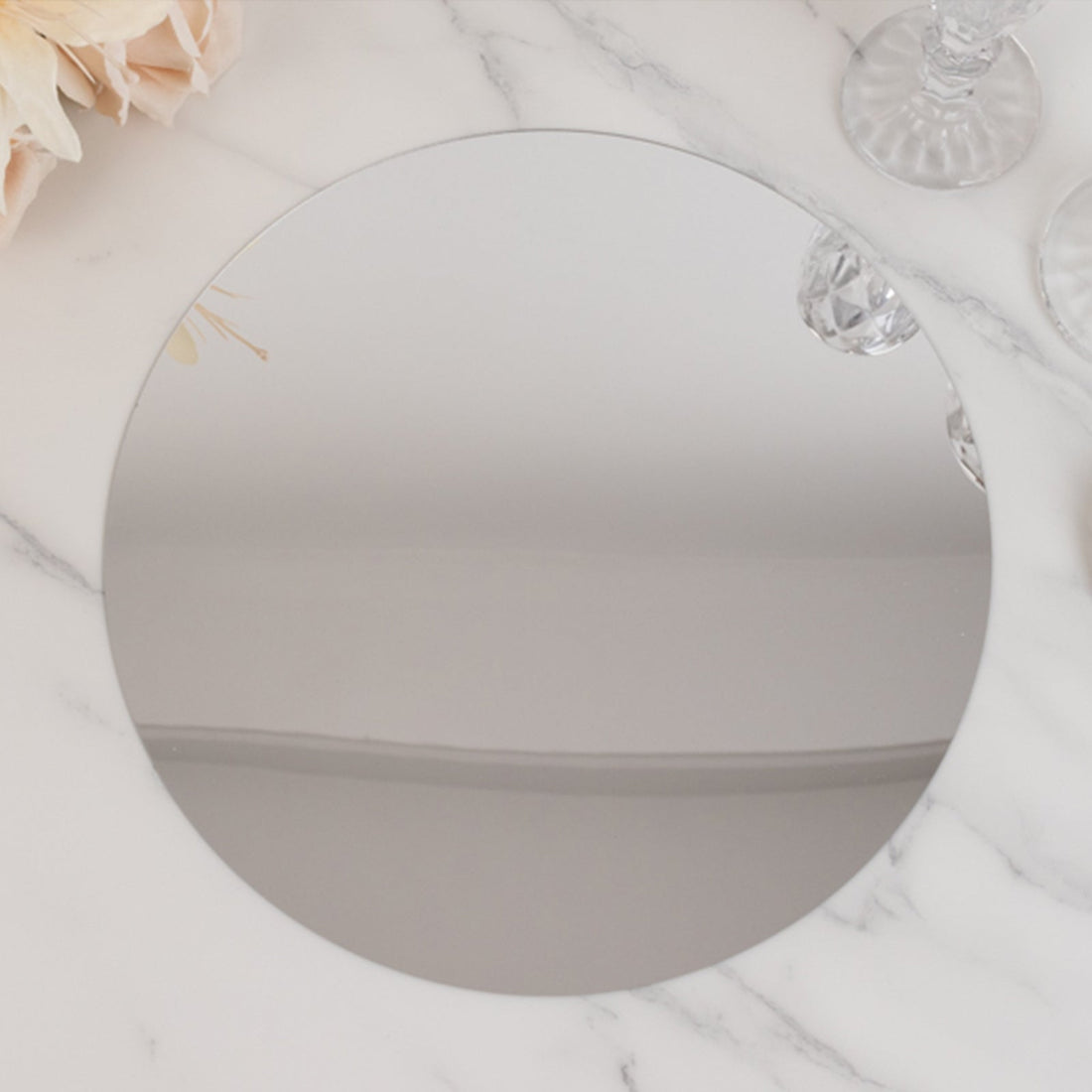 Round reflective mirror plate on a marble surface.
