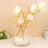 Gold branch floral arrangement in a glass vase with decorative pearls.