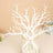 White decorative tree branches in a vase with pearls.