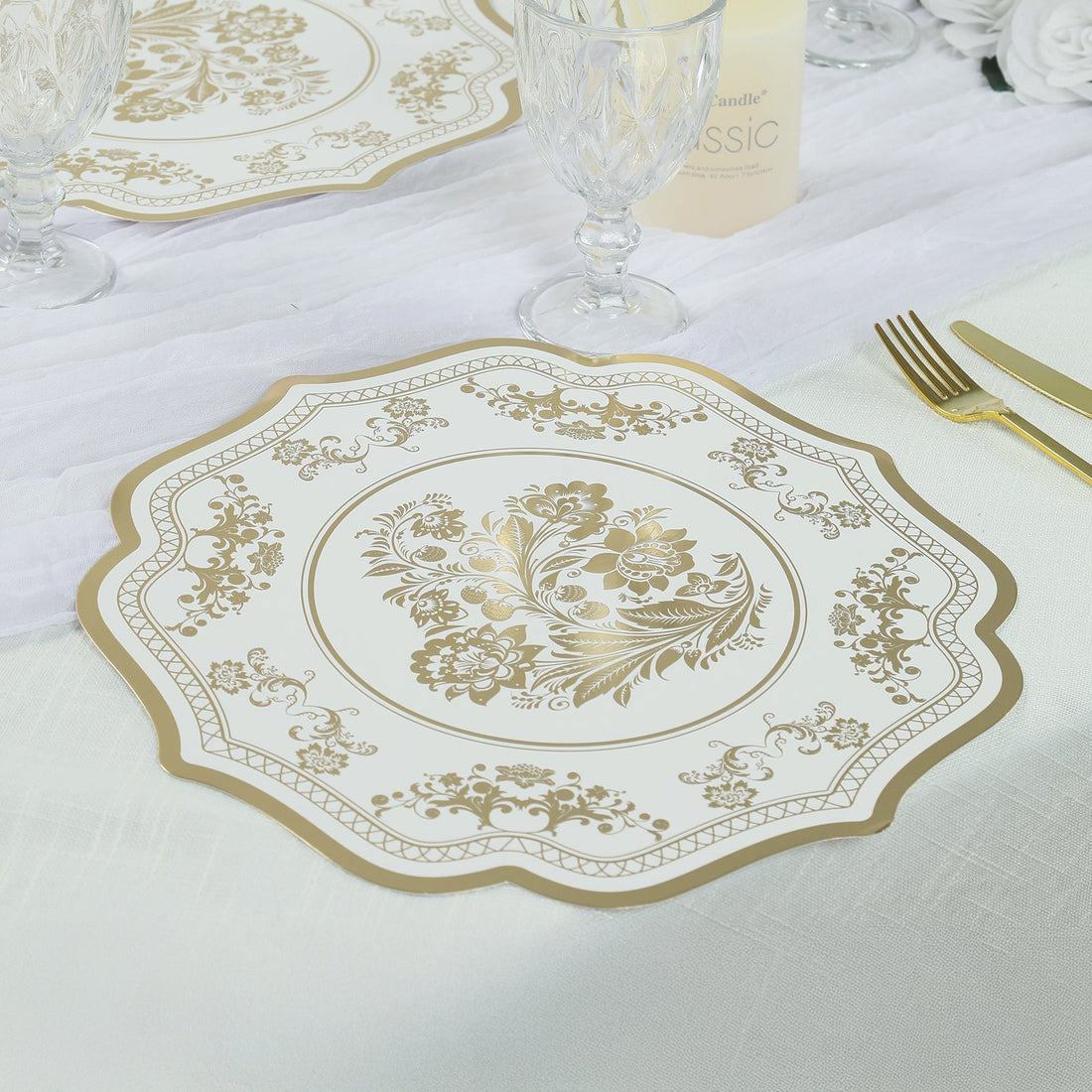 Elegant gold floral design paper plate on a dining table setting.
