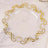 Clear plate with elegant gold scroll design on the rim.