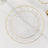 Clear plates with gold scalloped edges stacked on a marble surface.