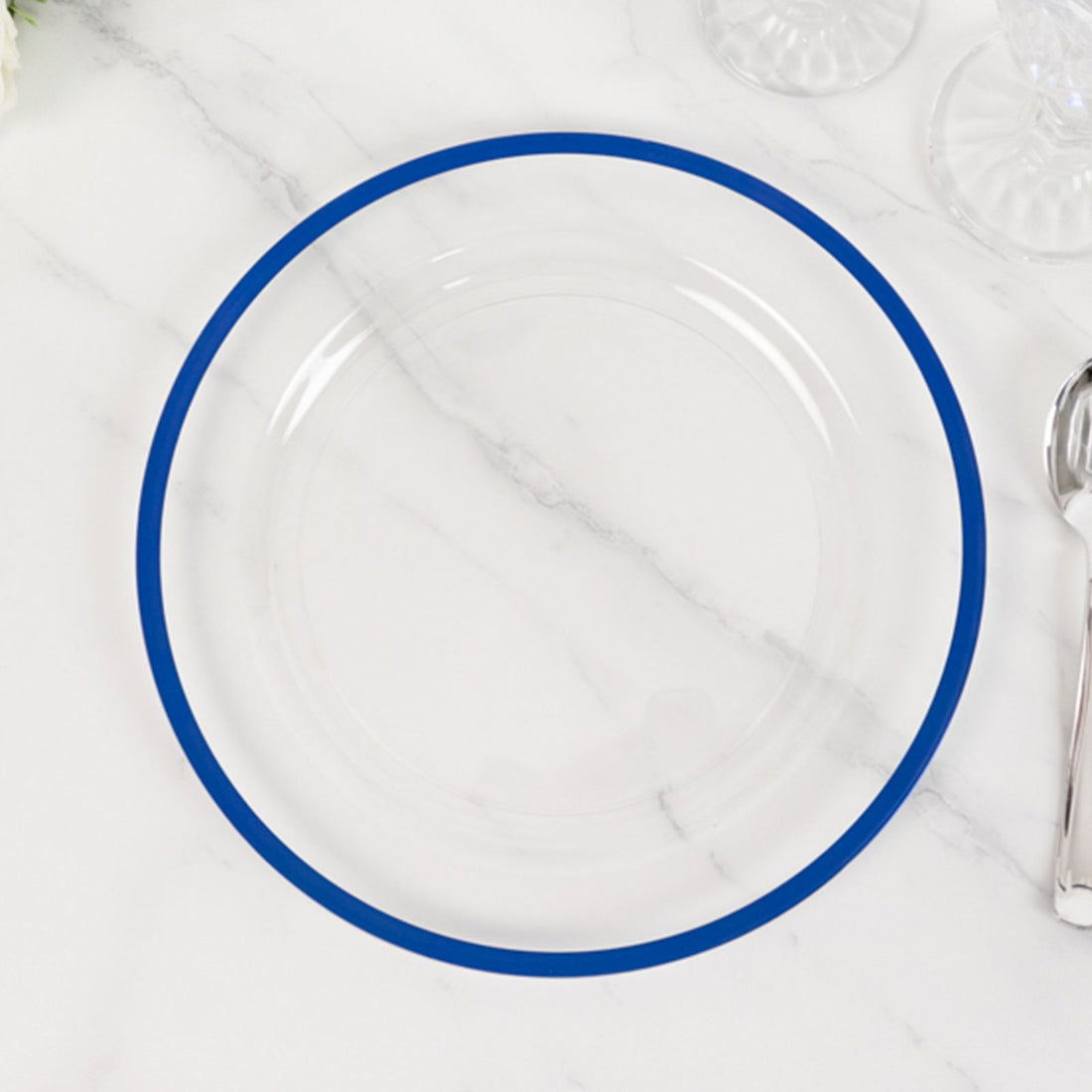 Clear plate with blue rim on marble surface.