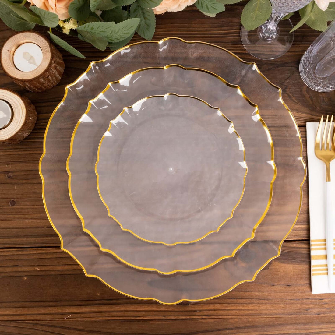 Elegant clear plates with gold edges, stacked on a wooden table.